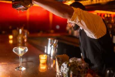 a bartender at Bar Merce pouring a drink