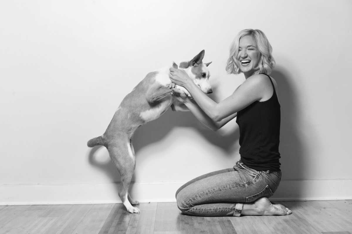 fern kneels next to her dog bette, who is standing on two legs